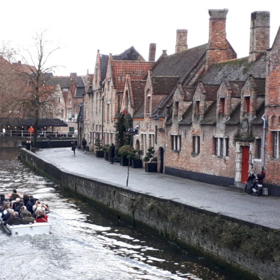 Boats making their way up the canal in Bruges