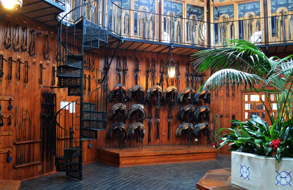 Tack room with working equipment below and performance pieces above
