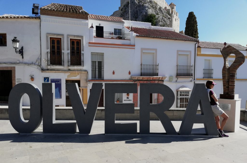 Marcella leaning against an Olvera Sign near the castle