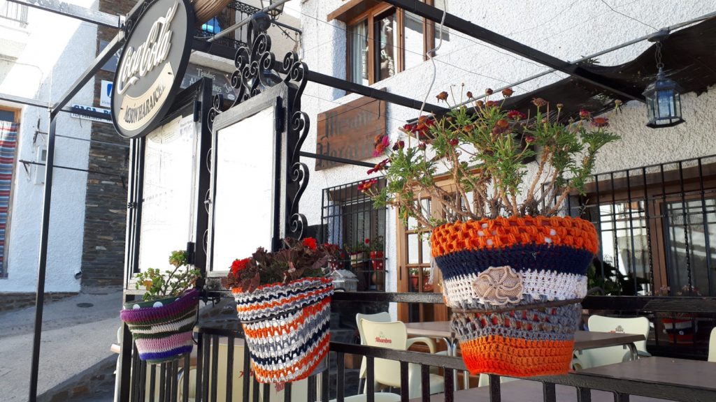 Small cafe in Trevelez with flowerpots in knitted jumpers!