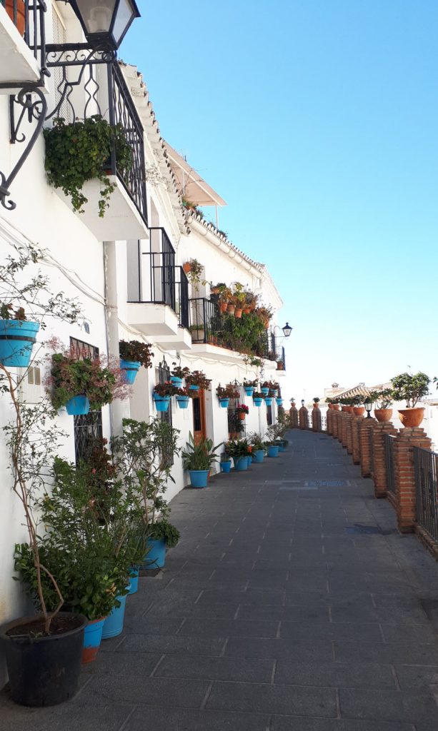 Pretty Mijas Pueblo street lined with blue flower pots