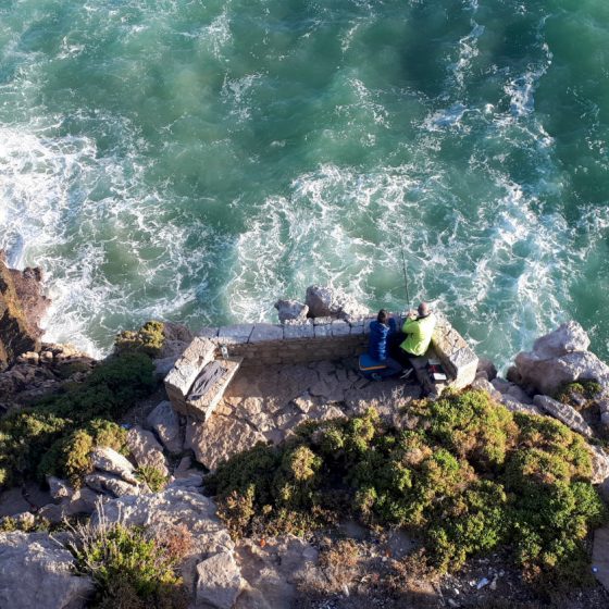Looking down on a couple fishing in Peniche