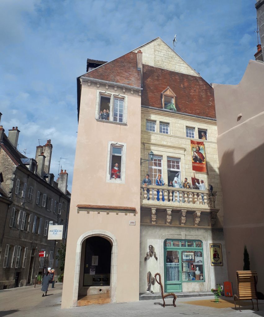 A painted building in Dole with Louis Pasteur in the top window