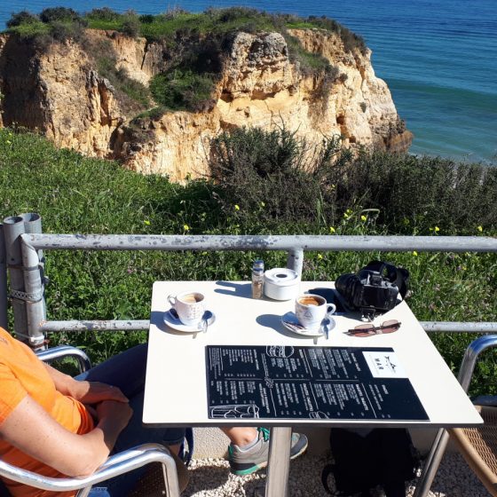 A pew with a view overlooking the beach at Lagos with a coffee.