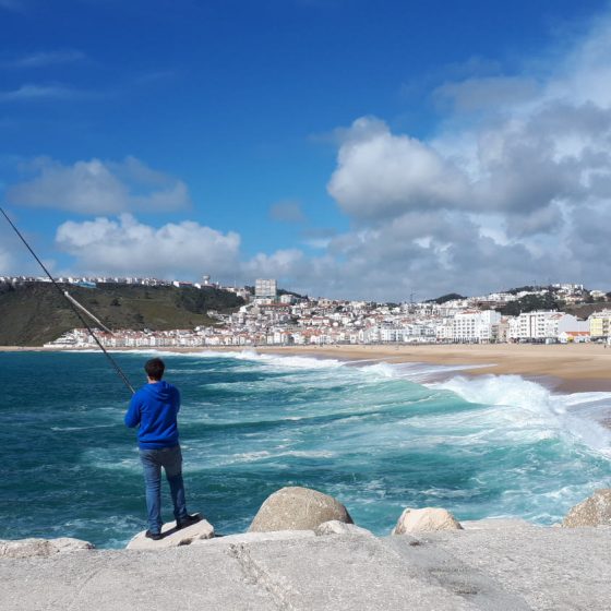 A fisherman trying his luck in the surf