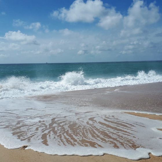 The surf rushing in over the silky sands