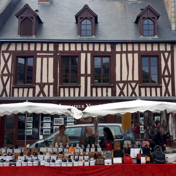 Market stalls in front of traditional half-timbered building
